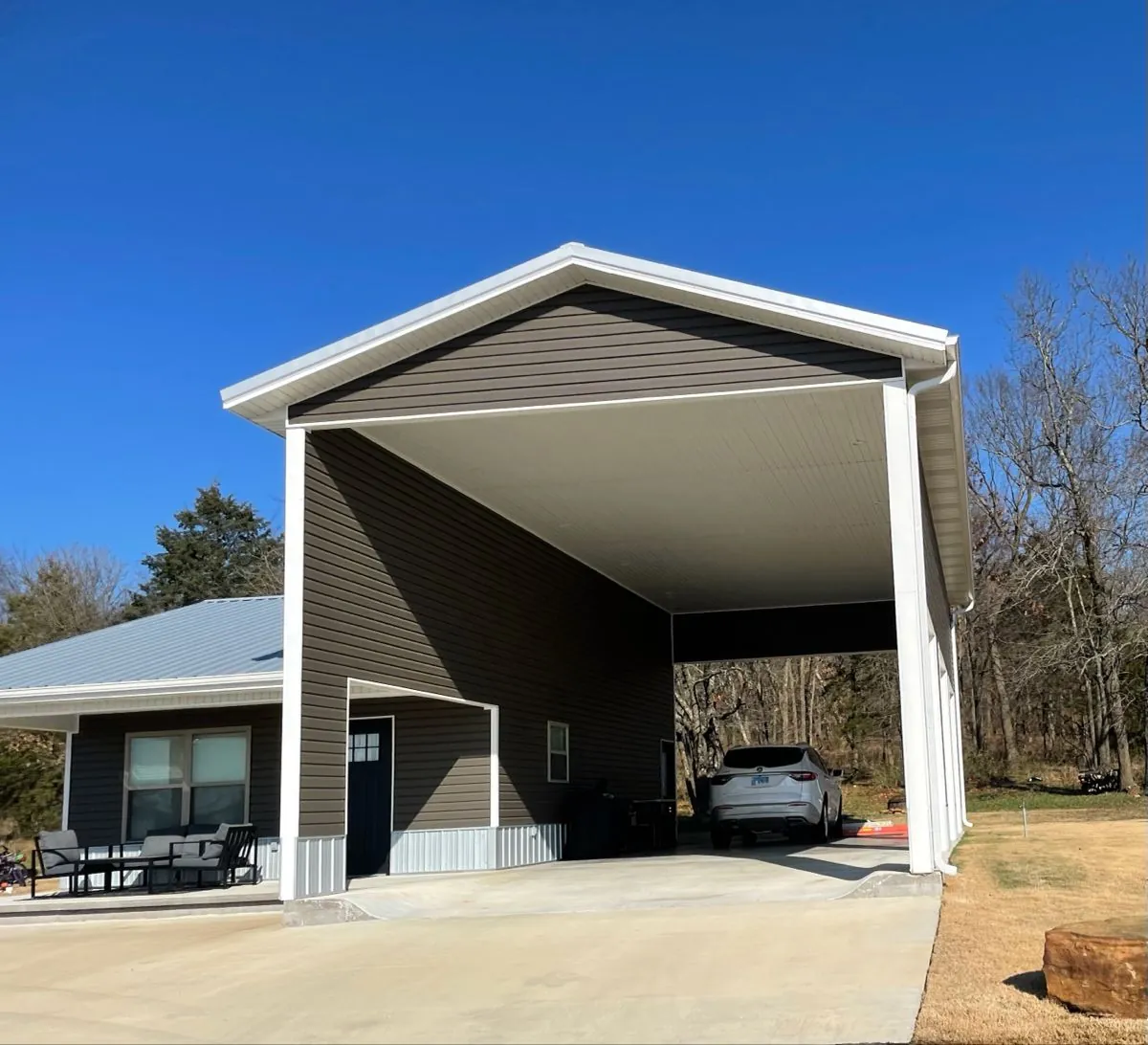Tall steel RV cover attached to a home, with an SUV parked underneath